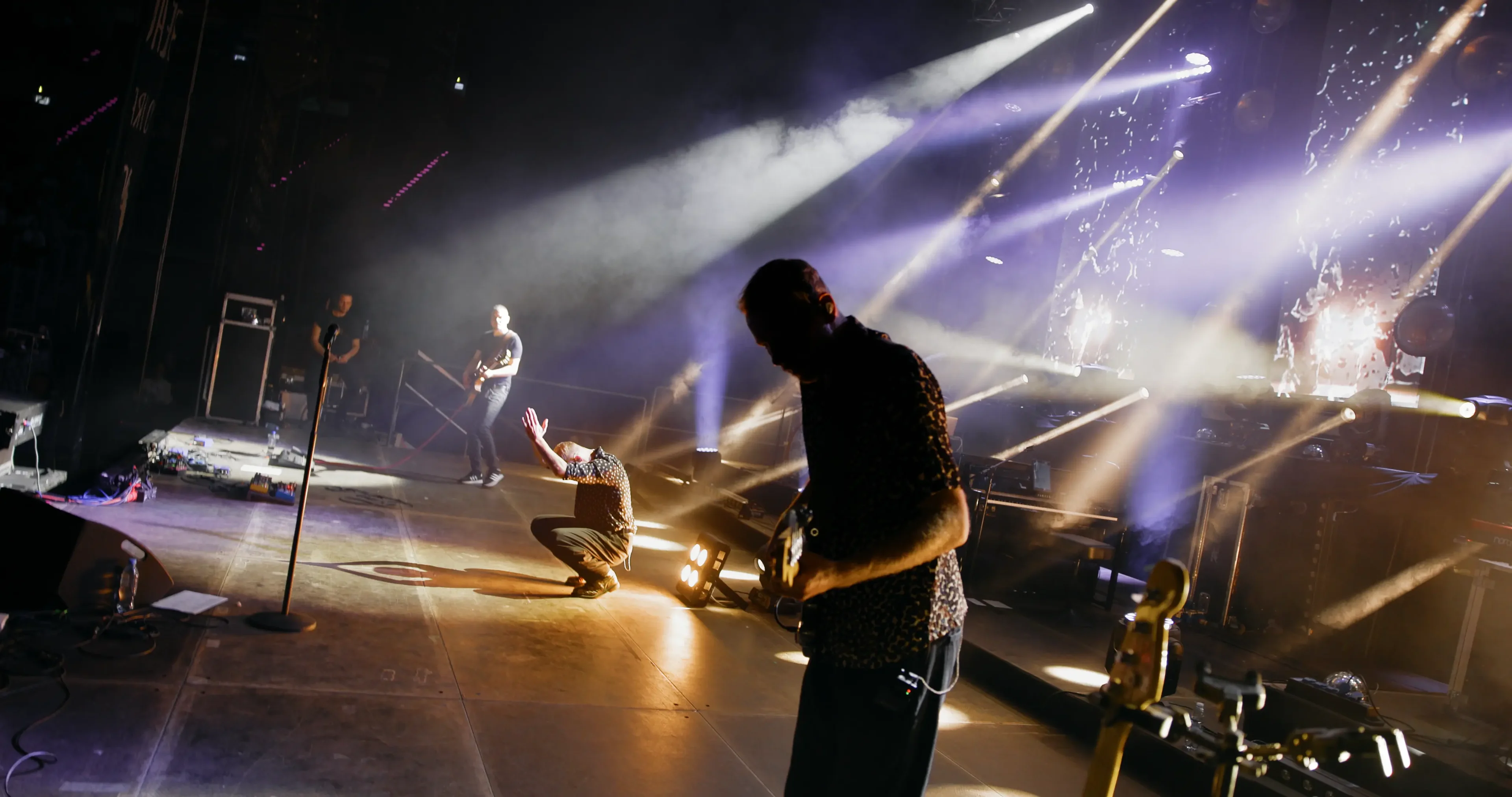 LemON on stage at Tauron Arena Kraków, shot from the wings during the documentary's concert sequence — stage light cutting through haze over the crowd.